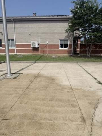 Concrete pad behind a commercial building being surface cleaned