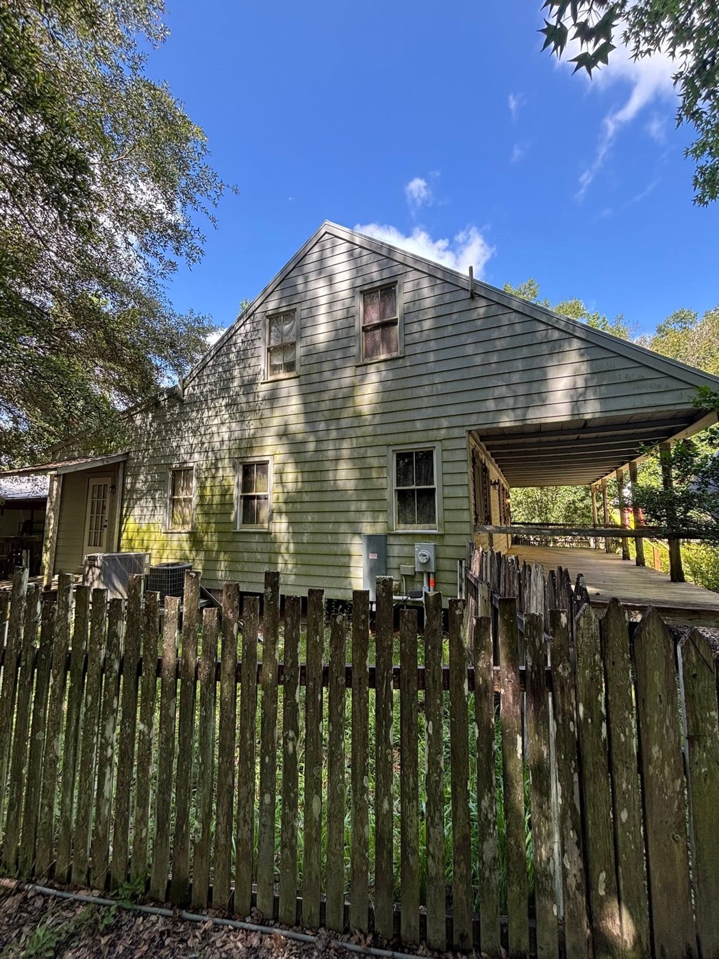 House siding covered in green algae and mildew before soft washing